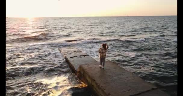 スローモーションショットの若い女性が石の桟橋に立って — ストック動画