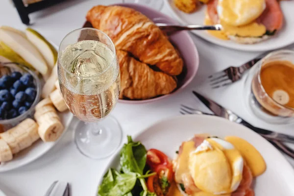 Glas champagne close-up op tafel met verschillende ontbijt en brunch gerechten — Stockfoto