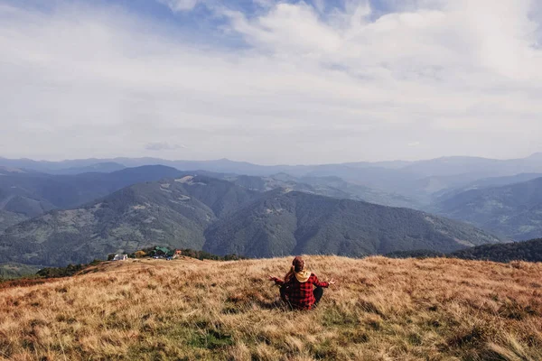 Mulher sentada em meditação posar olhando para os picos da montanha — Fotografia de Stock