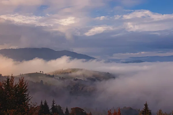 Bellissimo paesaggio montano. Cielo con nuvole e nebbia sulle colline — Foto Stock