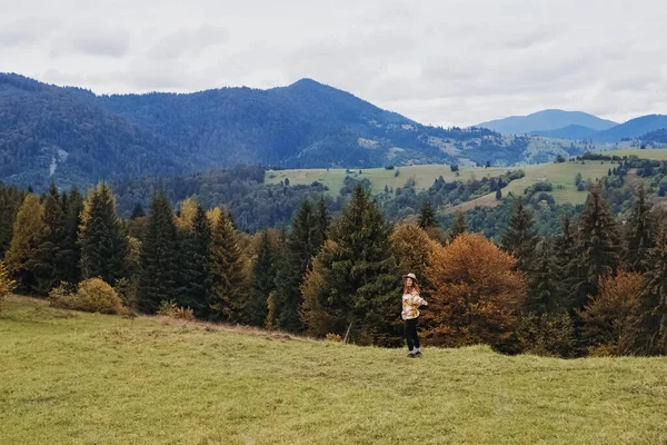 Giovane donna in cappello godersi la natura in montagna autunno. — Foto Stock