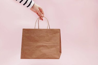 Pembe arka planda el işi kağıt çanta..
