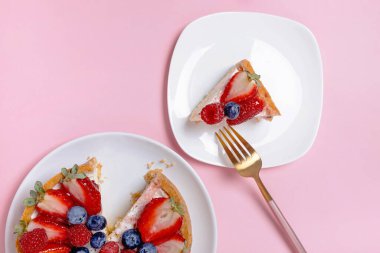 Pembe arka planda taze çilekli cheesecake.