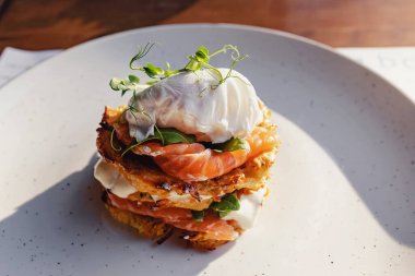 Stack of hash brown with salmon and poached egg on the top. clipart