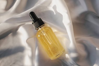 Üzerinde beyaz bez damlası olan küçük cam bir şişe.