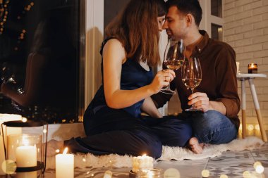 Man and woman having date, sitting on the floor with a lot of burning candles