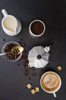 Moka pot, kahve çekirdekleri, süt, şeker ve taze sıcak espresso ile sakin bir hayat.