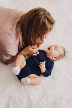 Mutlu genç anne küçük sevimli bebeğiyle konuşuyor.