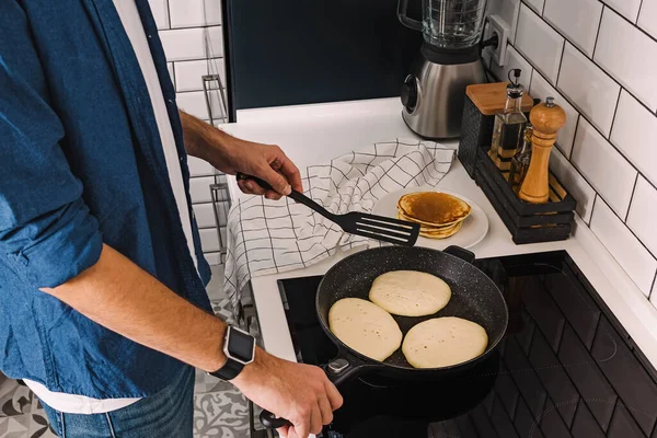 Чоловік готує млинці на сніданок або бранч — стокове фото