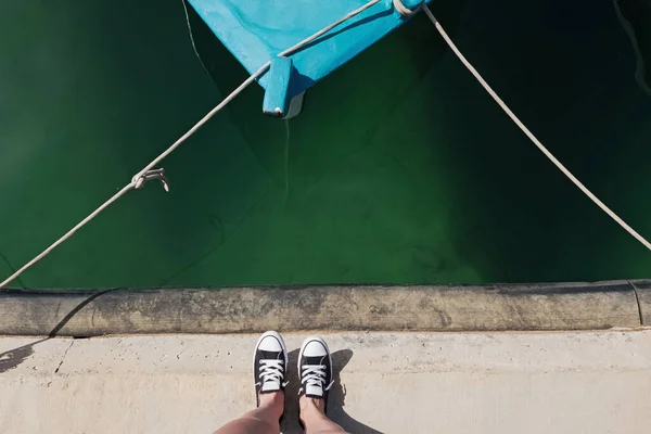 Pés femininos em sapatilhas de pé perto da água — Fotografia de Stock