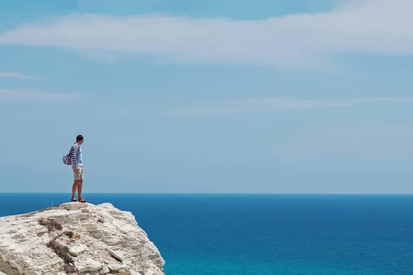 Homem em pé na rocha e olhando para o mar azul-turquesa — Fotografia de Stock
