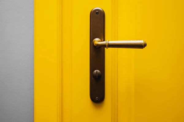 Gros plan de la porte de couleur jaune avec bouton de porte vintage. — Photo