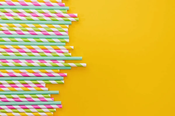 Multicolored party drinking straws on yellow background, — Stock Photo, Image