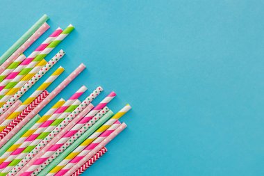 Çok renkli parti mavi arka planda pipet içiyor