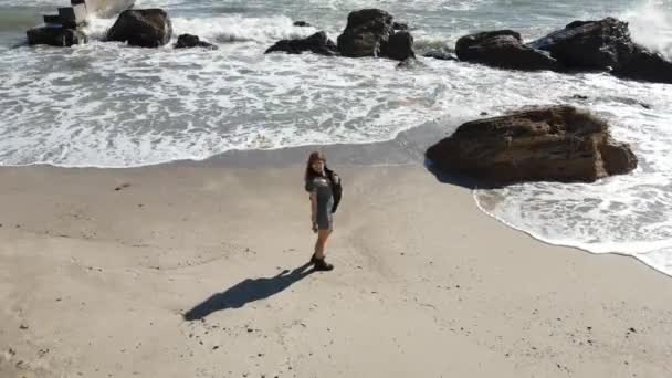 Mulher em botas de couro e vestido curto desfrutando de dia ensolarado perto do mar — Vídeo de Stock
