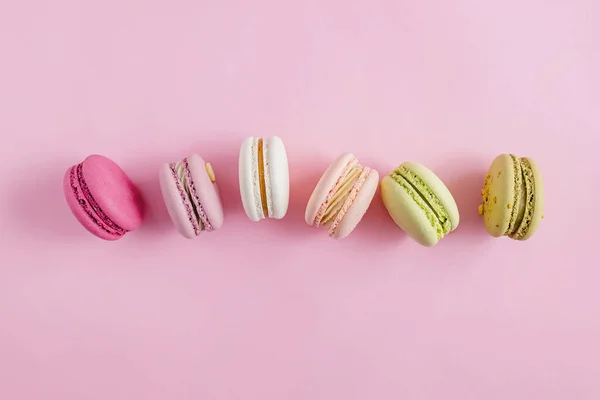 Macarons de dessert colorés sur fond rose pastel — Photo