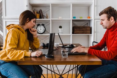 Evde aynı odada çalışan genç bir çift..