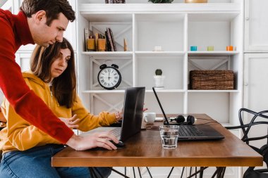 Şaşırmış bir kadın ekranında adama bir şey gösteriyor..