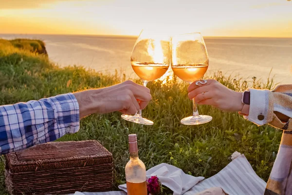 Casal clinking com dois copos de vinho rosa no pôr do sol. — Fotografia de Stock