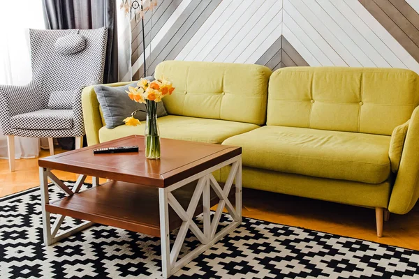 Sala de estar con sofá verde claro y mesa de centro de madera con flores —  Fotos de Stock