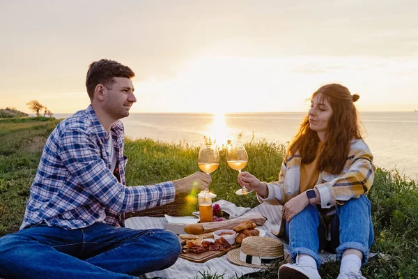 Paar picknicken op groen gazon met uitzicht op zee — Stockfoto