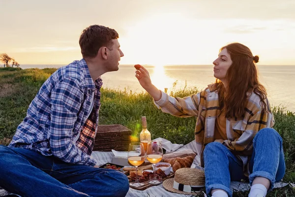 Paar picknicken op groen gazon met uitzicht op zee — Stockfoto