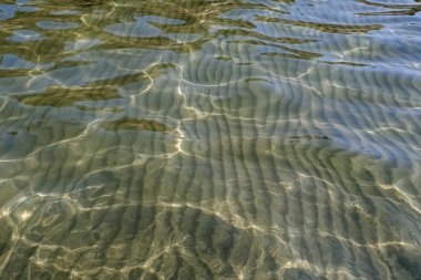 Kristal berrak su dalgalandı ve güneşli yansımalar