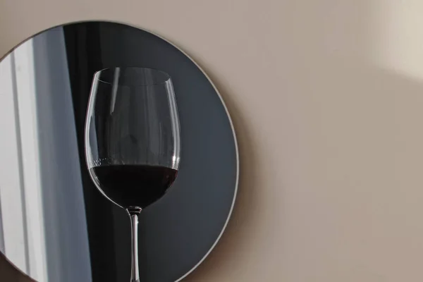 Bicchiere di vino rosso che si riflette in un piccolo specchio rotondo — Foto Stock