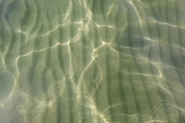 Agua cristalina ondulada y reflejos soleados — Foto de Stock