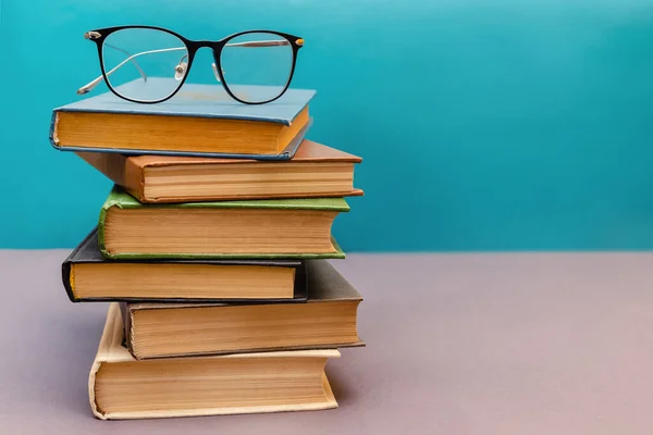 Stack of books with reading glasses on top — Stock Photo, Image