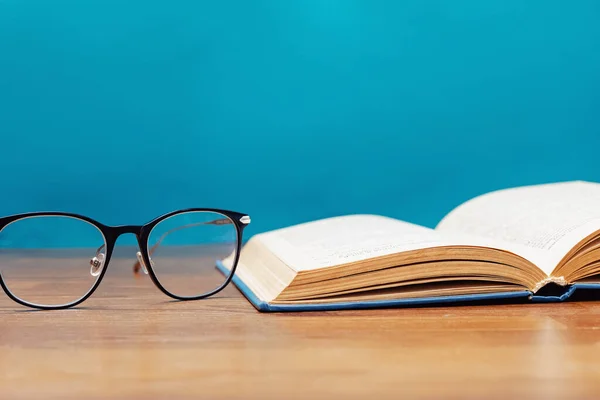 Close-up of reading glasses and opened book — 图库照片