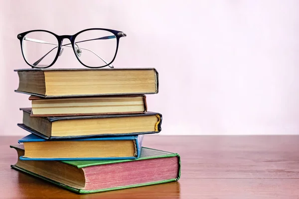 Montón de libros con gafas de lectura en la parte superior —  Fotos de Stock