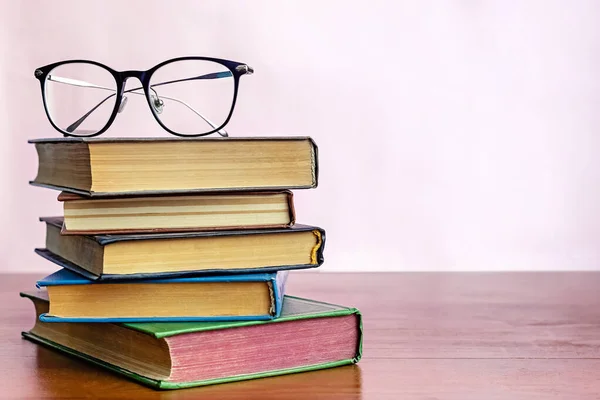 Bücherstapel mit Lesebrille obenauf — Stockfoto