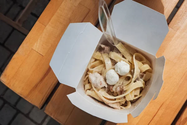 Tagliatelle pasta com cogumelos uma caixa de papel — Fotografia de Stock