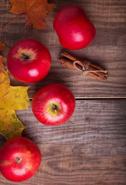 Červená jablka a žluté listy — Stock fotografie