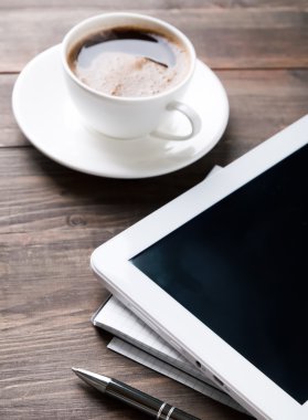 Tablet, kağıt defter ve kahve masada