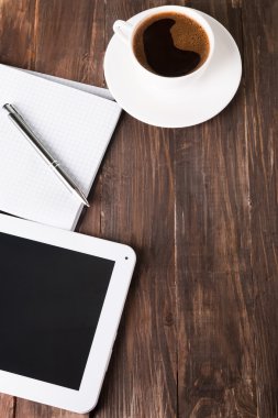 Tablet, kağıt defter ve kahve masada