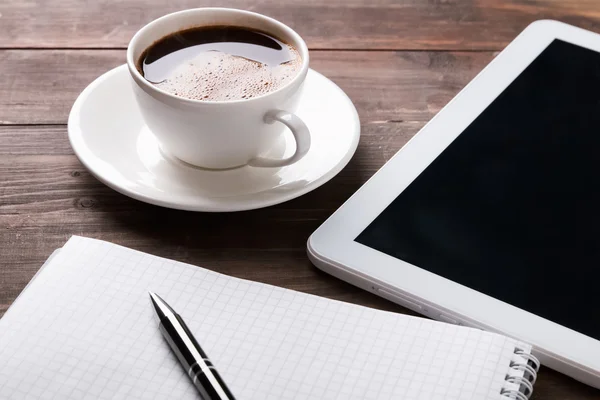 Tablet, caderno de papel e café na mesa — Fotografia de Stock
