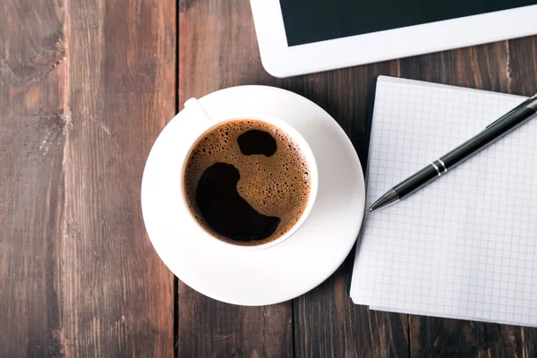 Tablett, anteckningsblock och kaffe på bordet — Stockfoto