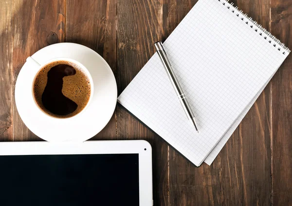 Tablett, anteckningsblock och kaffe på bordet — Stockfoto