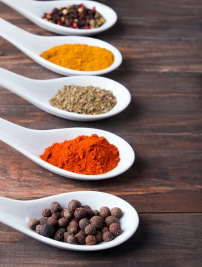 Beyaz bir kaşık içinde farklı baharatlar