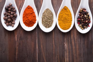 Beyaz bir kaşık içinde farklı baharatlar