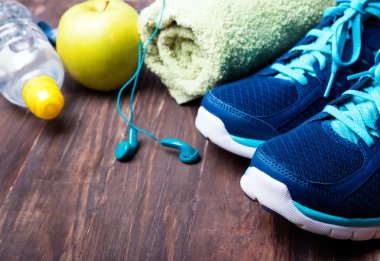  Spor ayakkabı, su, havlu ve ahşap arka plan üzerinde kulaklık