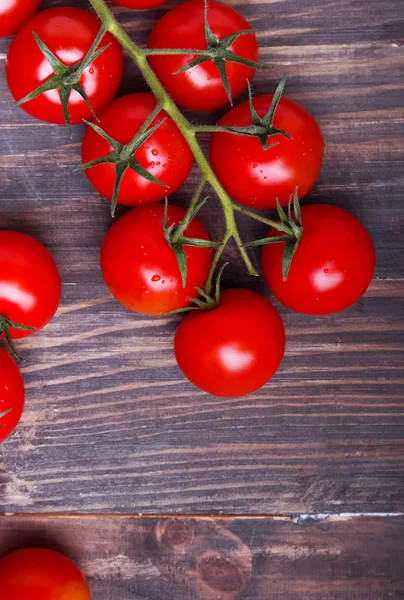 Red cherry rajčata na dřevěné pozadí — Stock fotografie