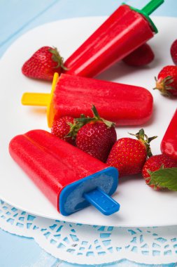 Beyaz pl renkli çubuklarla parlak çilek popsicles