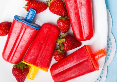 Beyaz pl renkli çubuklarla parlak çilek popsicles