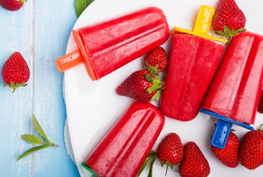Beyaz pl renkli çubuklarla parlak çilek popsicles