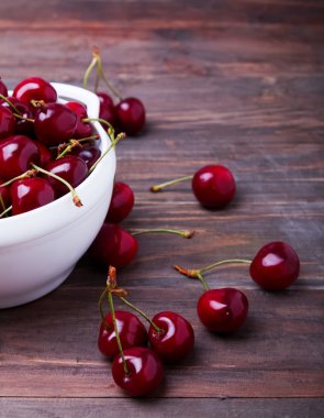 Ahşap masa yakın çekim üzerinde bir kase kiraz