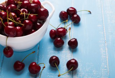 Kiraz bir kase üzerinde mavi ahşap masa yakın çekim