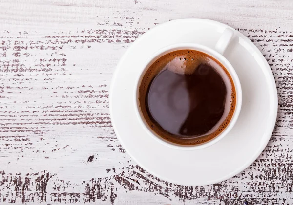 Xícara de café na mesa de madeira branca — Fotografia de Stock